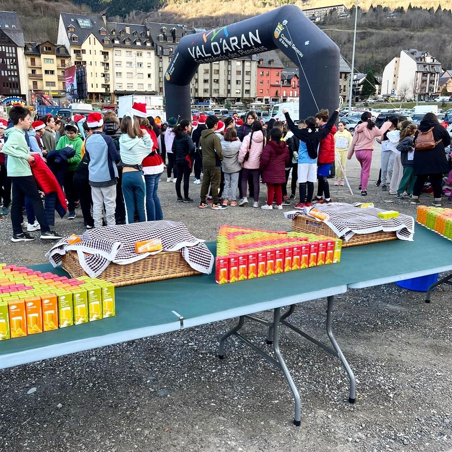 A large group of people are gathered around a table with food and an inflatable arch that says valdaran