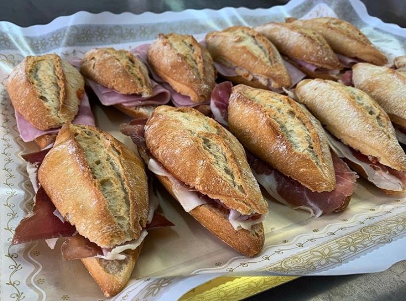 A tray of sandwiches with ham and cheese on them