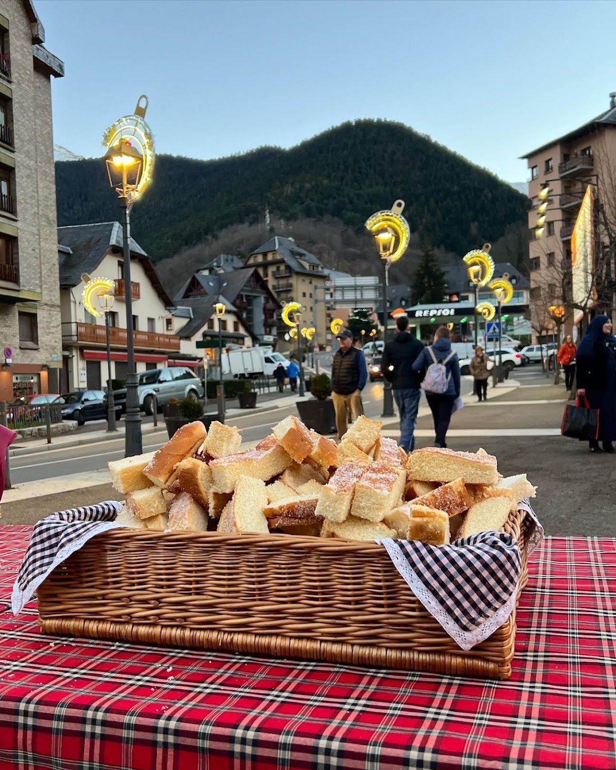 A basket of bread is sitting on a table in a city.