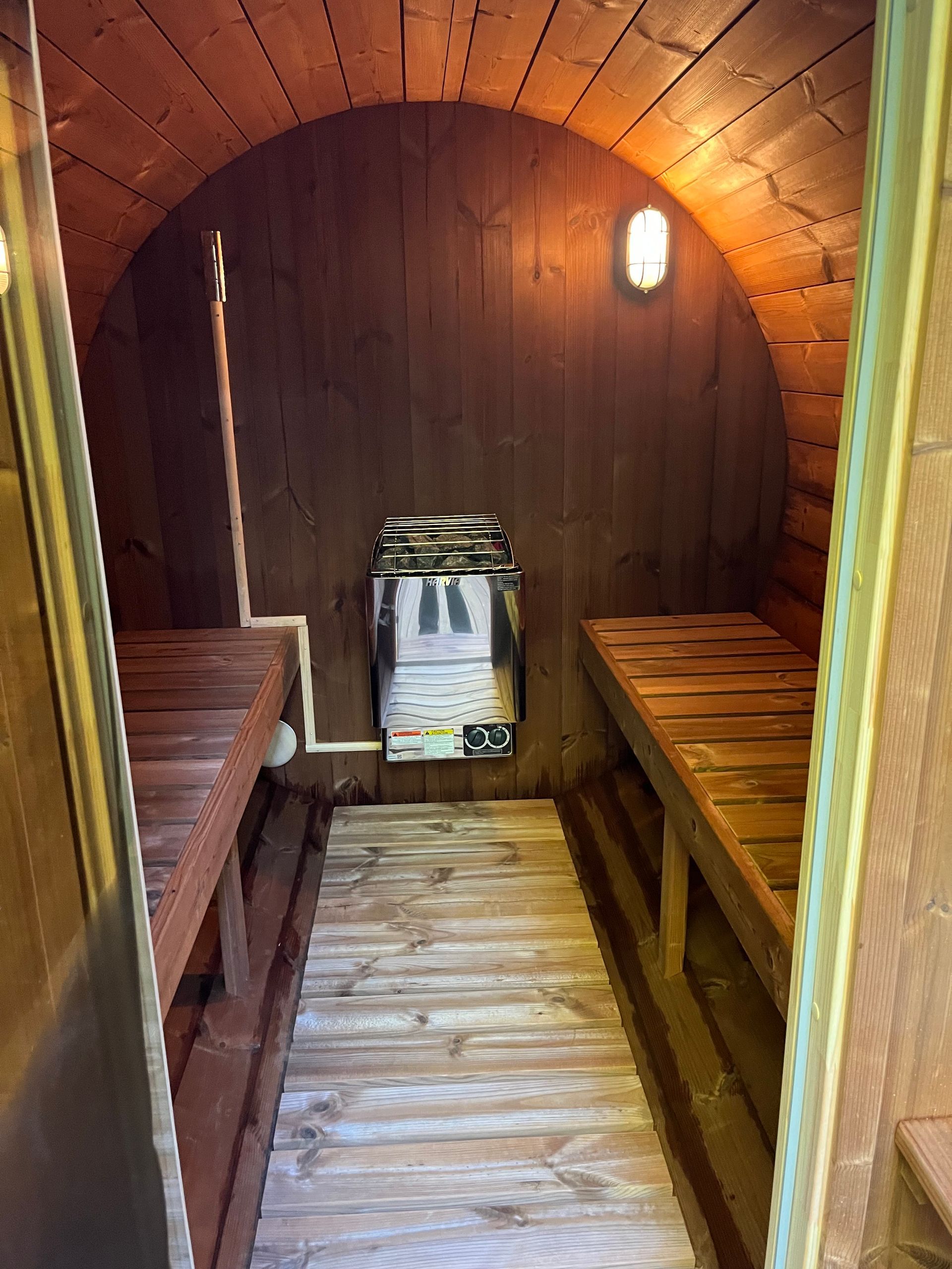 Interior hallway under construction; exposed wooden studs, ceiling beams, and wiring.