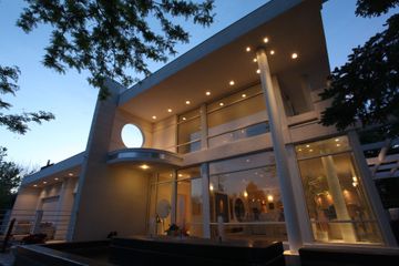 A large white building with a lot of windows is lit up at night