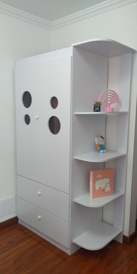 Armario blanco con almacenaje y estantes. Suelo de madera y paredes blancas.