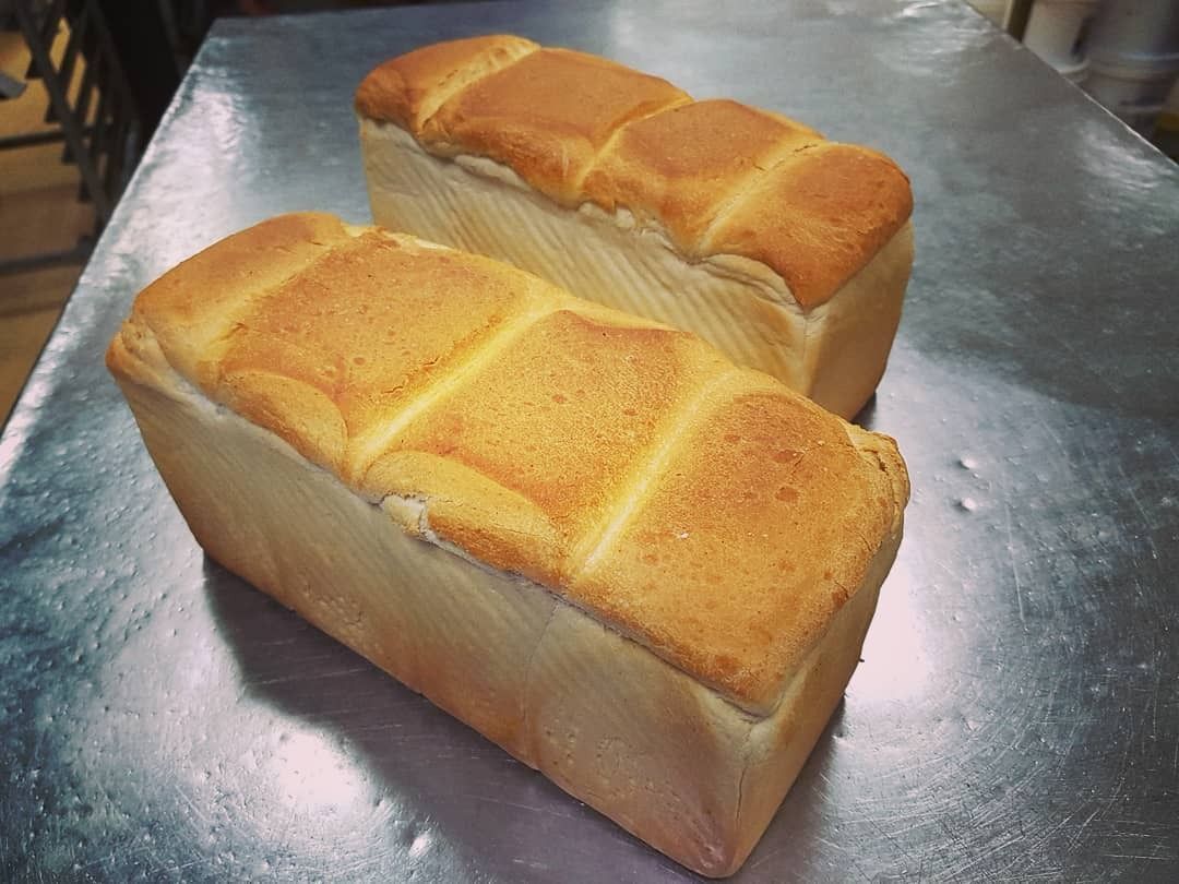 Golden-brown croissants piled high on a white tray, ready to eat.— Atherton Bakehouse in Atherton, QLD