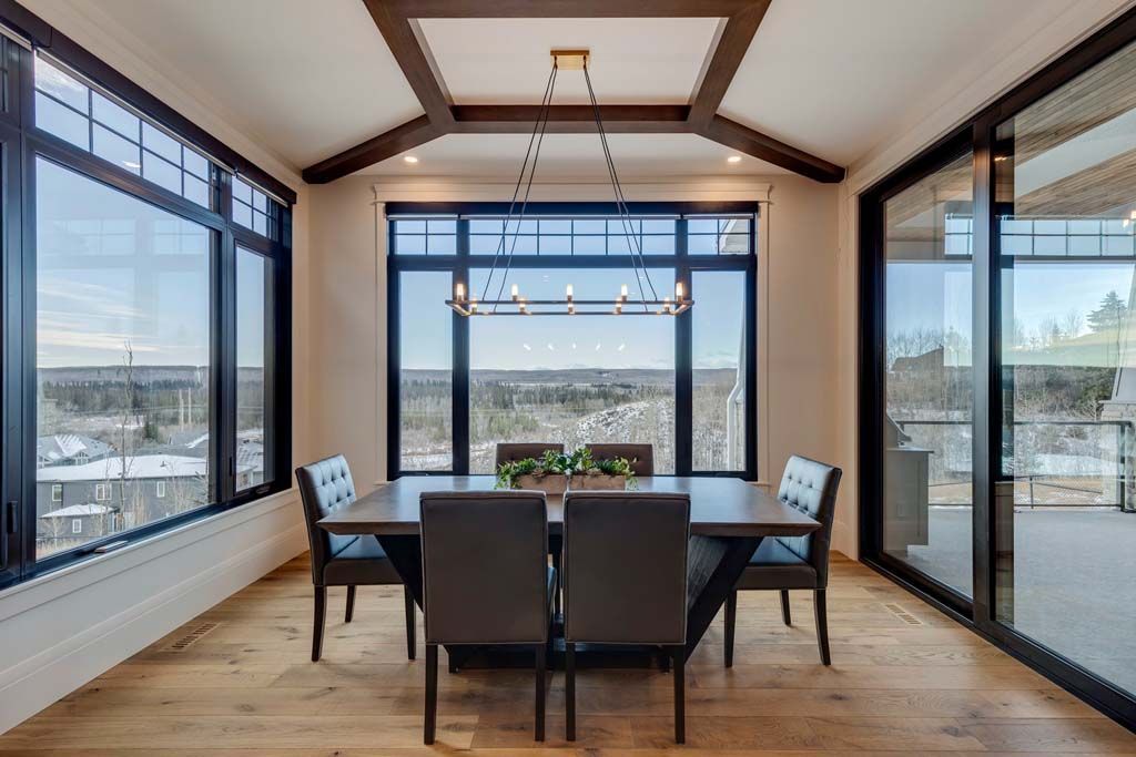 Modern kitchen with brown cabinets, white island, and copper pendant lights. Four brown bar stools.