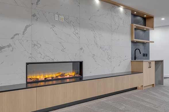 Modern living room with marble wall, fireplace, wood cabinetry, and bar area.