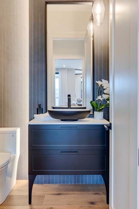 Modern bathroom with black vanity, white countertop, and black vessel sink.