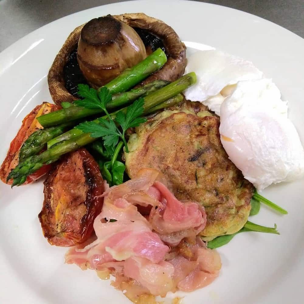 A White Plate Topped With A Variety Of Food Including Asparagus And Poached Eggs — Vines at 139 in Grafton, NSW