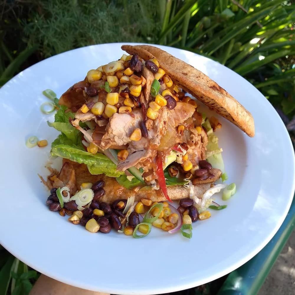 A Person Is Holding A White Plate With A Sandwich On It — Vines at 139 in Grafton, NSW