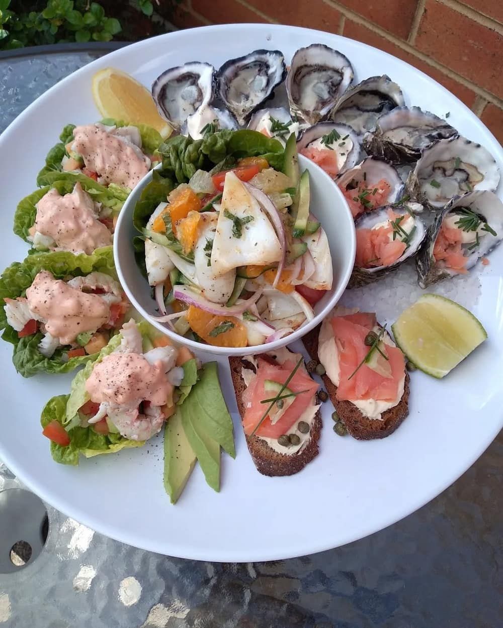 A White Plate Topped With A Variety Of Food Including Oysters — Vines at 139 in Grafton, NSW