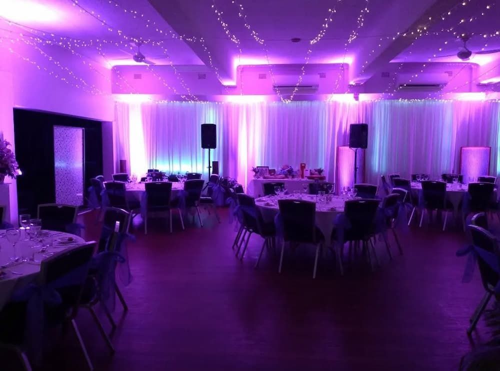 A Large Room With Purple Lights And Tables And Chairs — Vines at 139 in Grafton, NSW