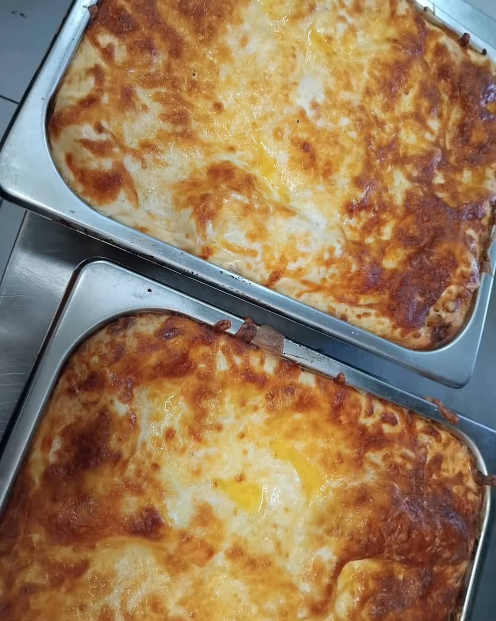 Two Pans Of Lasagna Are Sitting On Top Of Each Other On A Table — Vines at 139 in Grafton, NSW