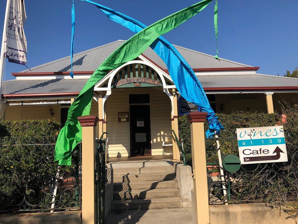 Cafe exterior with green and blue banners, steps leading to the door — Vines at 139 in Grafton, NSW