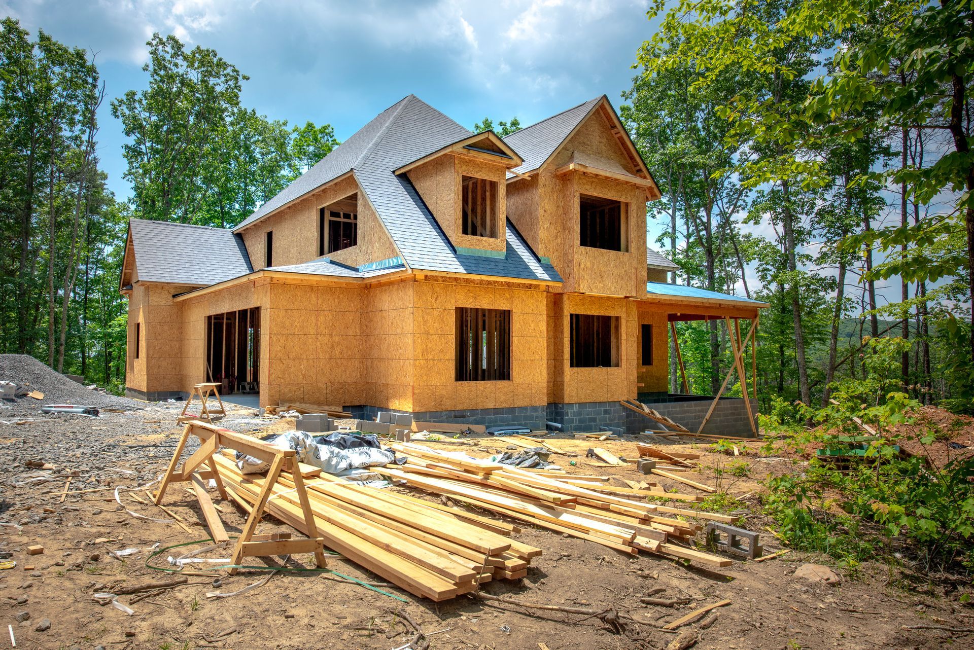 A large wooden house is being built in the middle of a forest.