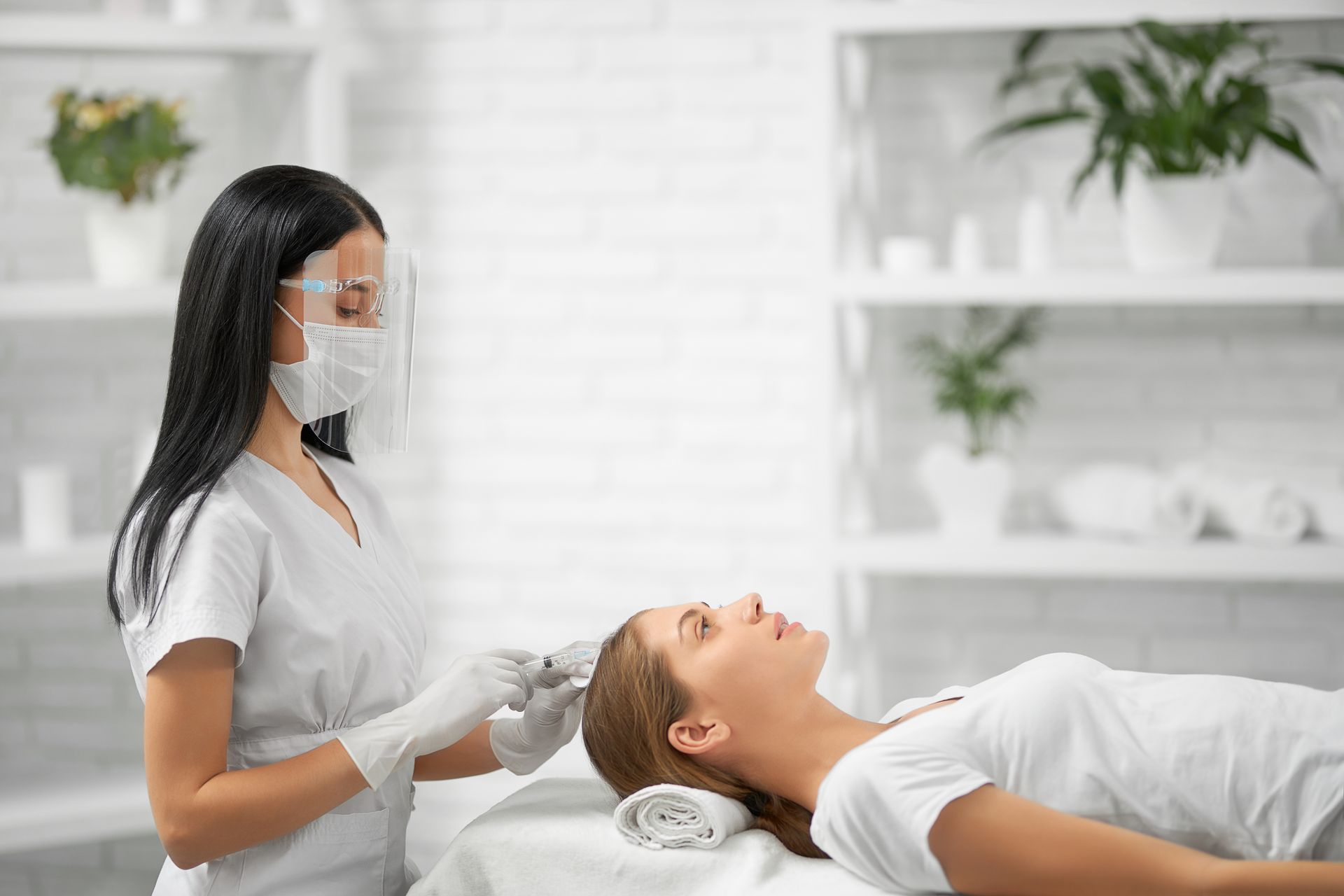 a woman is getting a hair treatment at a beauty salon .