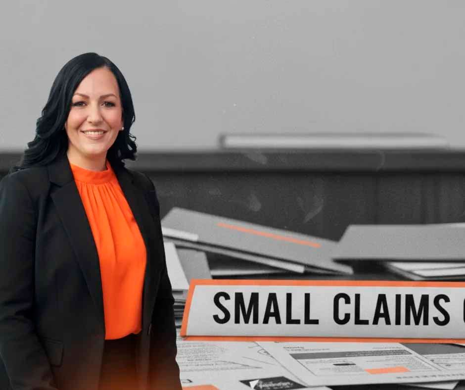 Woman in a black blazer and orange top smiles near a 