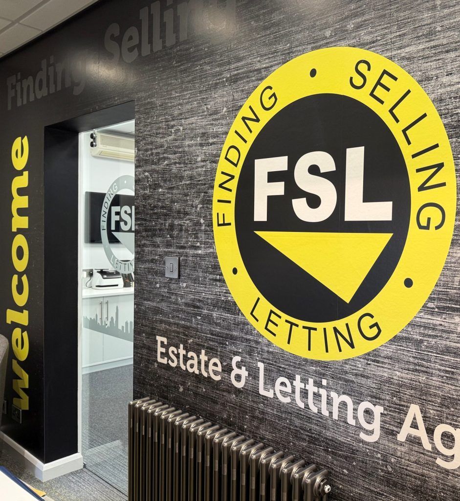 FSL estate and letting agency entrance with yellow circular logo on black wall