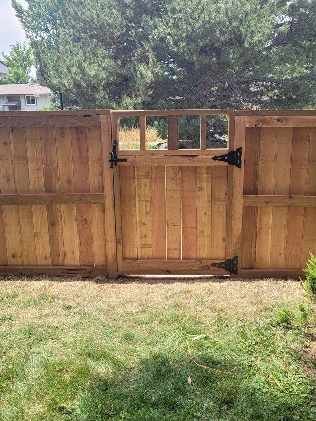 A wooden fence with a gate in the backyard.