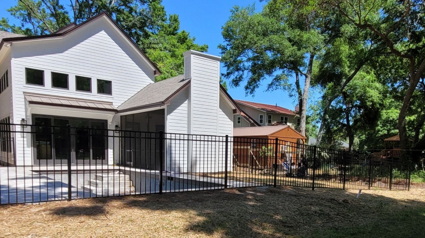 A white house with a black fence in front of it