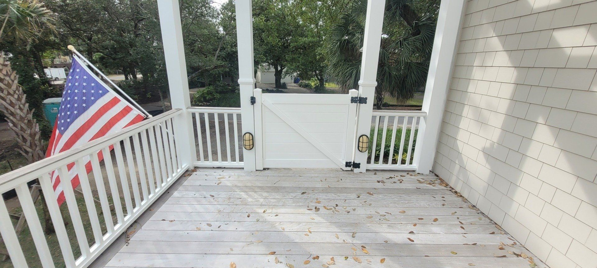 There is an american flag on the porch of a house.