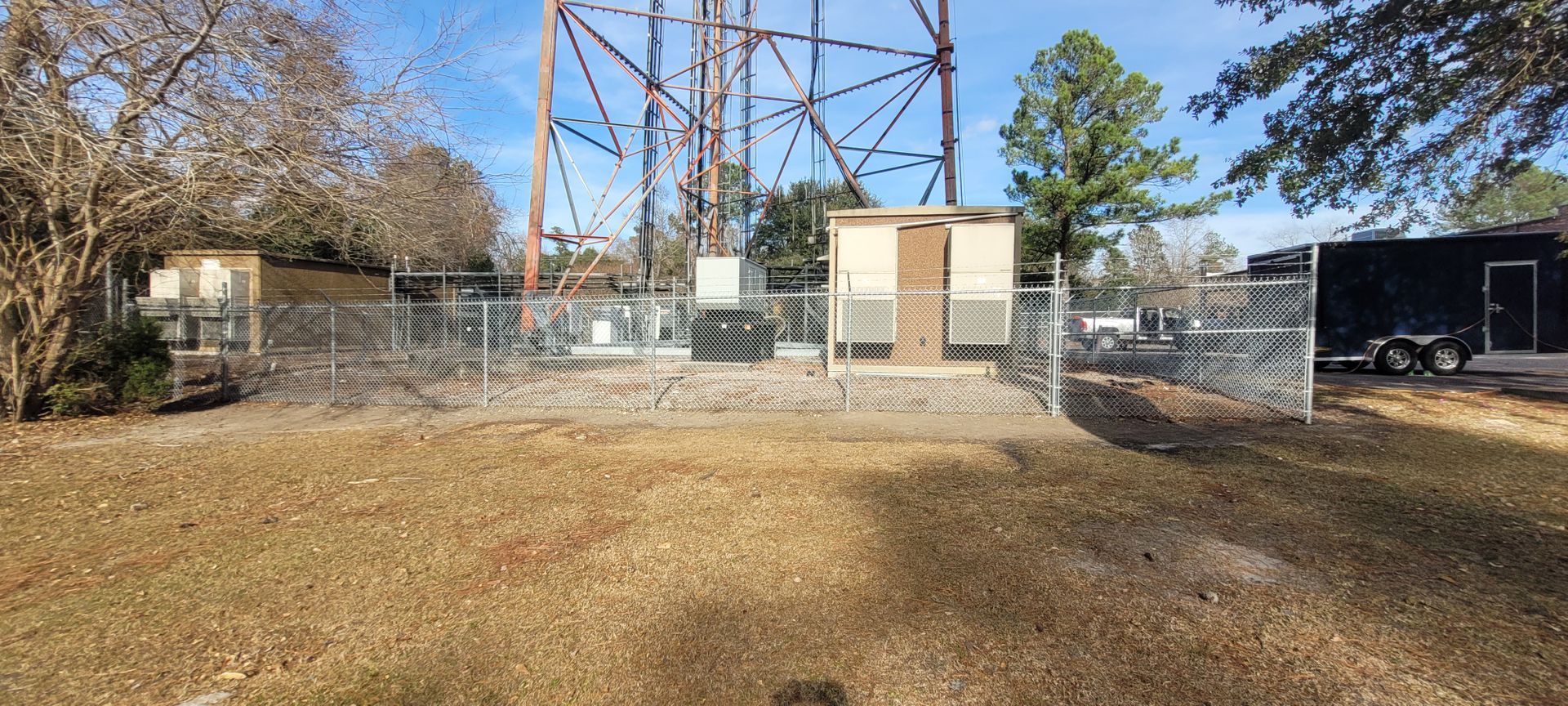 A fenced in area with a tower in the background.