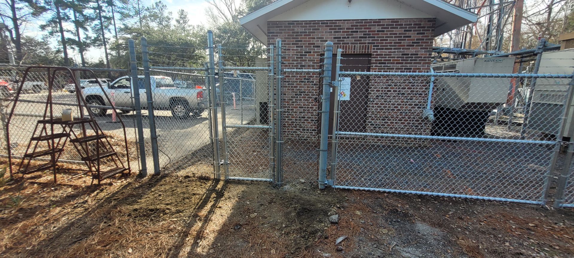 A chain link fence is surrounding a brick building.