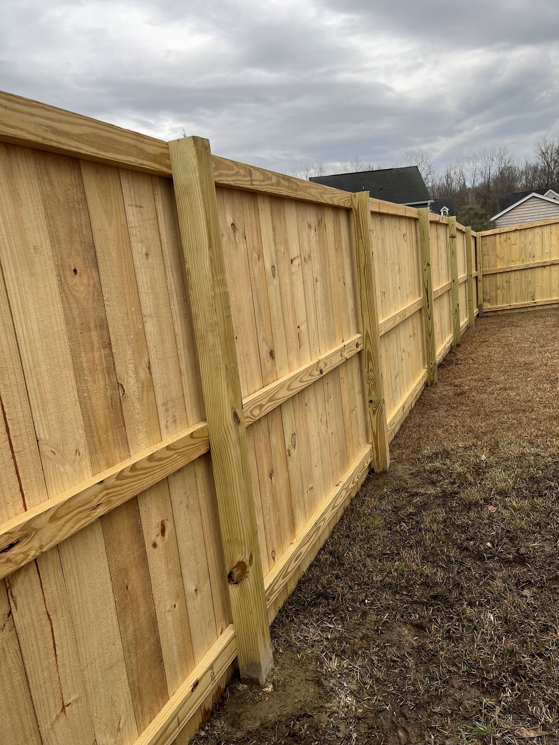 A wooden fence is sitting in the middle of a dirt field.