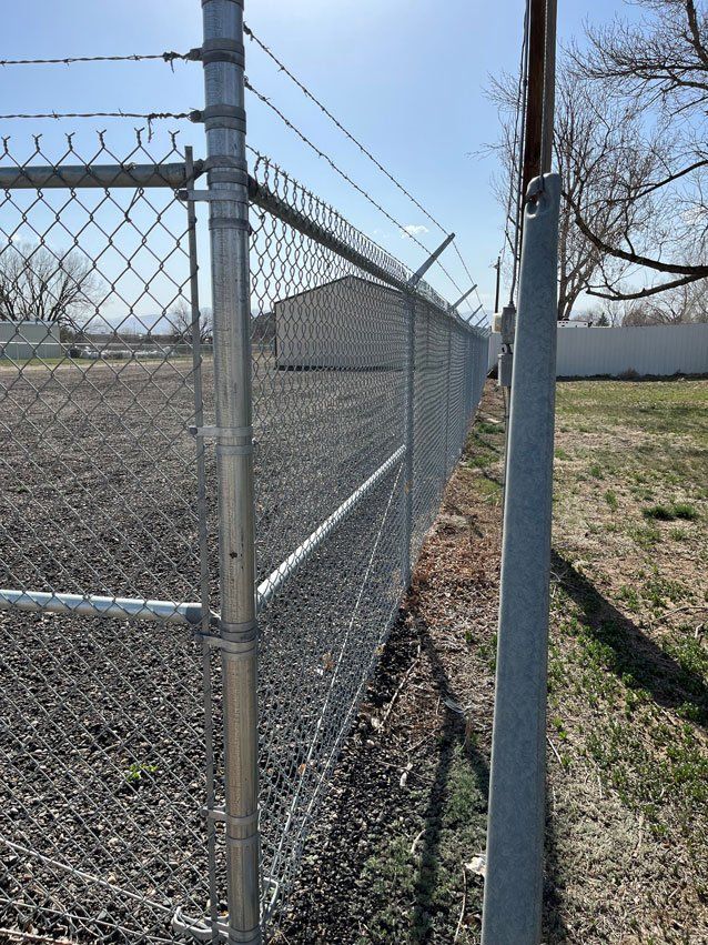 A chain link fence with barbed wire on top of it