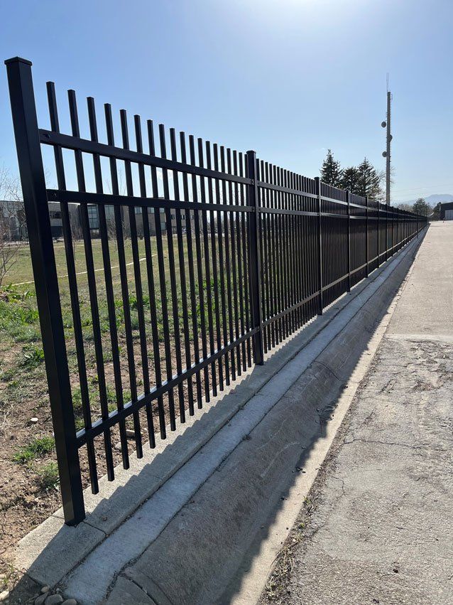 A black metal fence along the side of a road