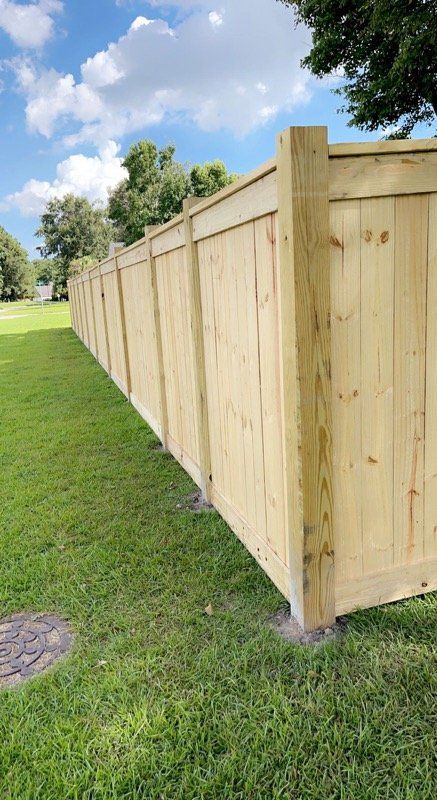 A wooden fence is sitting in the middle of a lush green field.