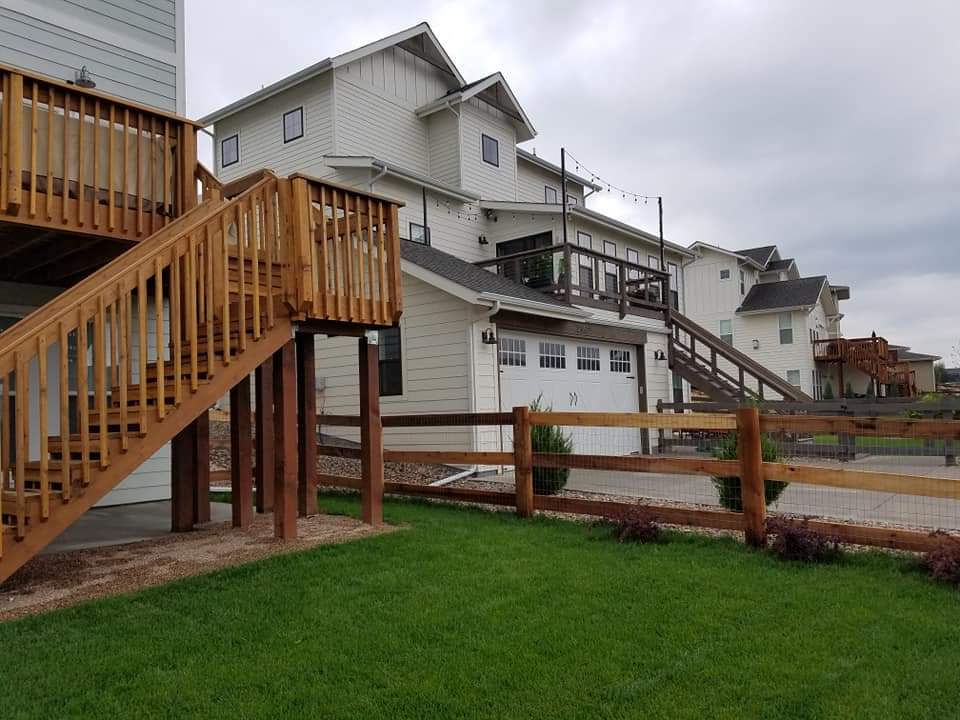 A house with a wooden deck and stairs in front of it