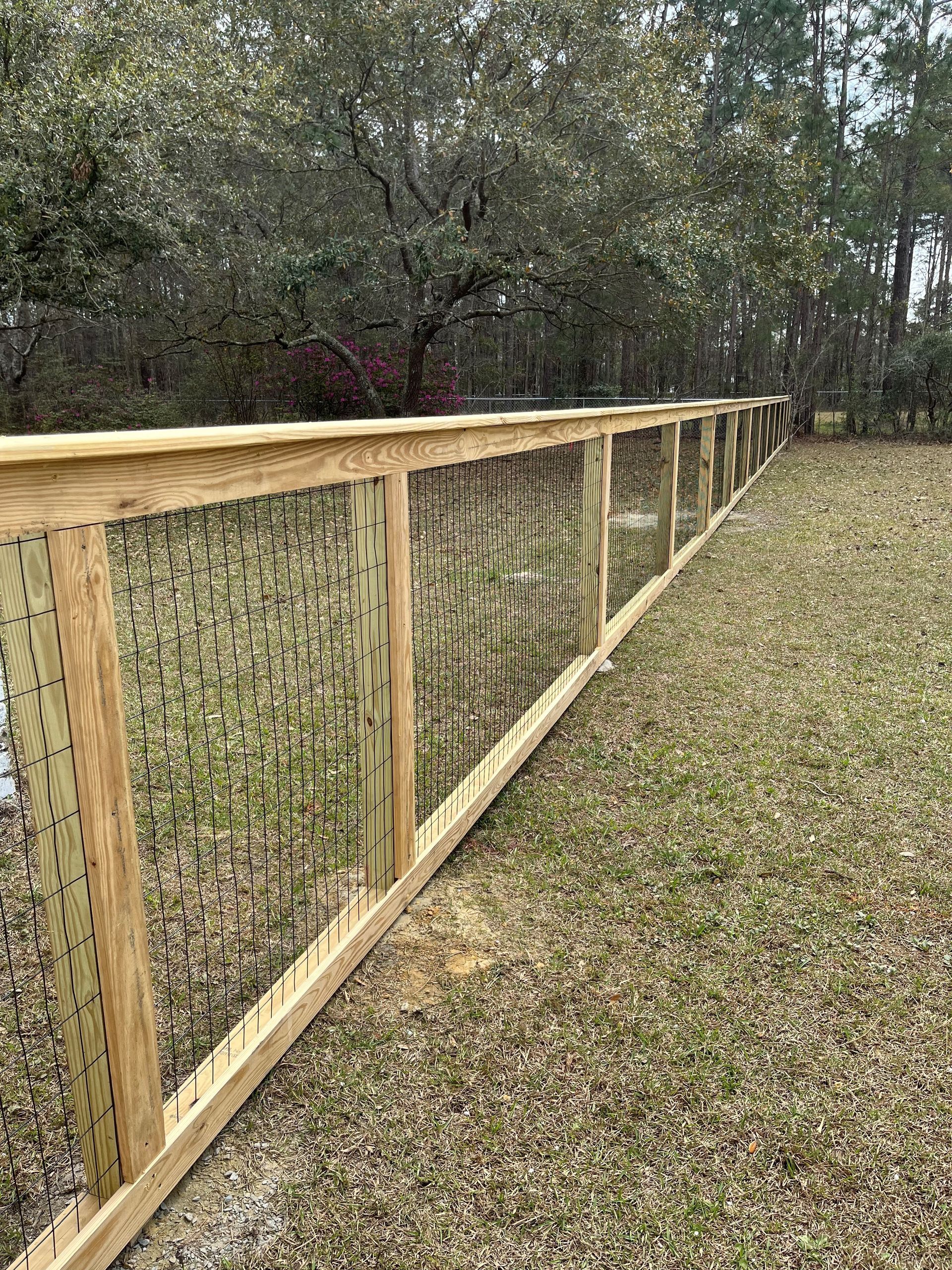 A wooden fence is sitting in the middle of a grassy field.