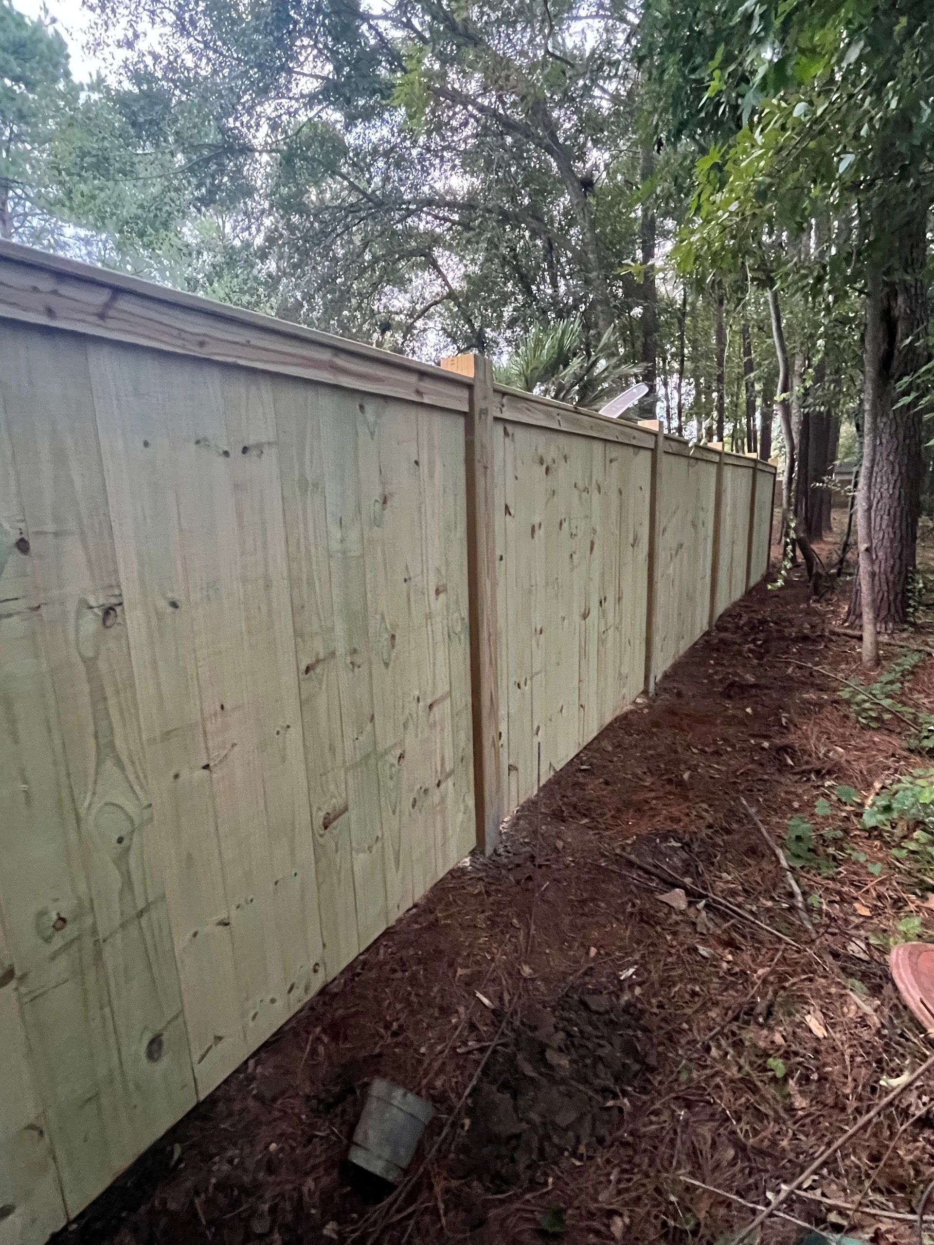 A wooden fence is sitting in the middle of a forest.