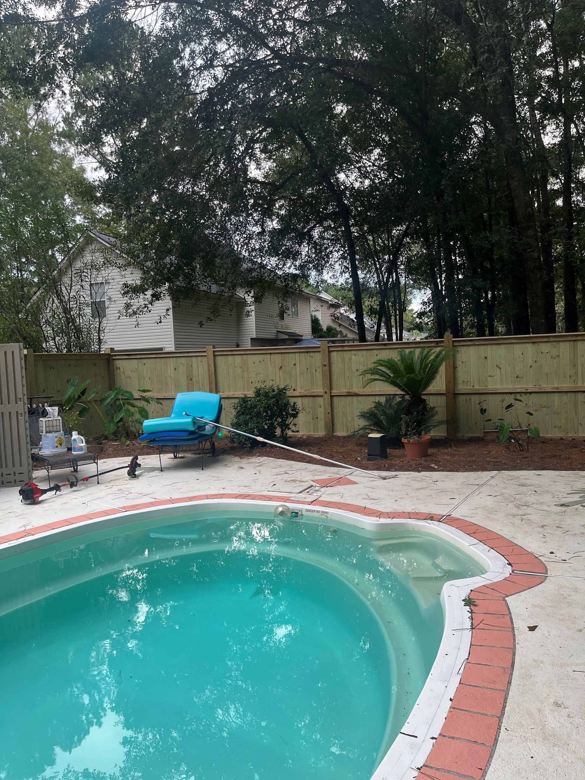 A swimming pool with a wooden fence surrounding it