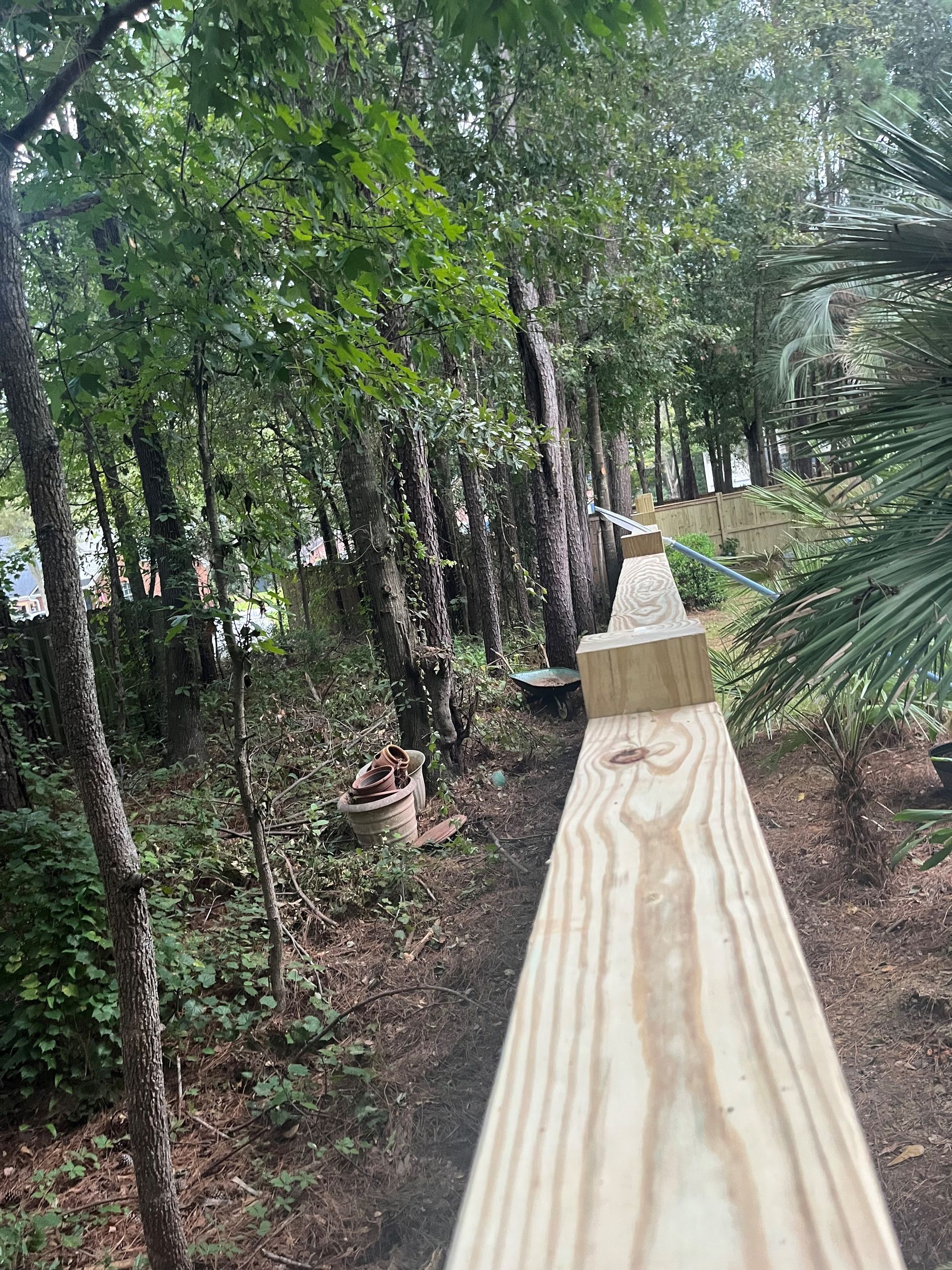 A wooden bridge is being built in the middle of a forest.