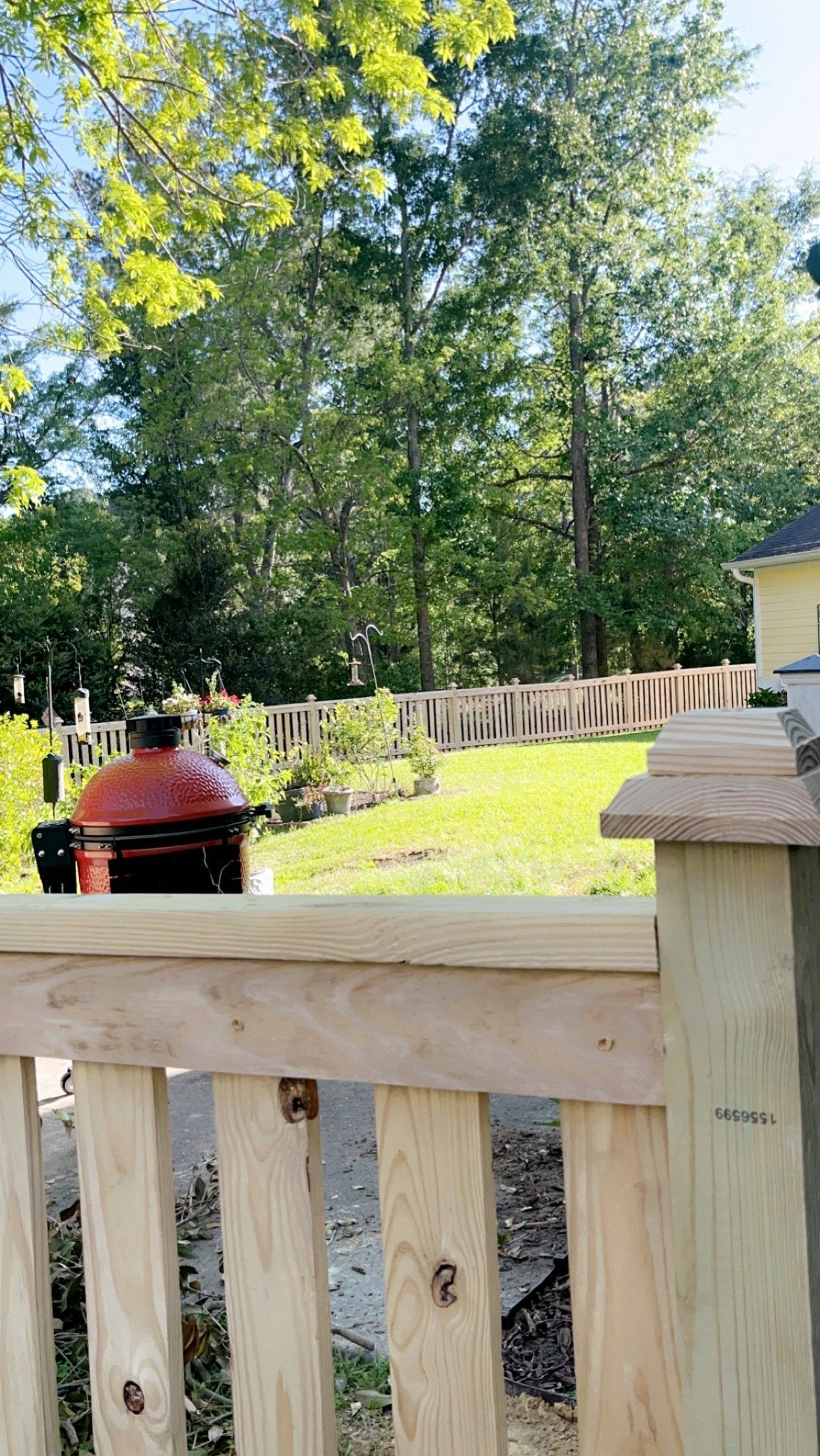 A grill is sitting on top of a wooden fence.