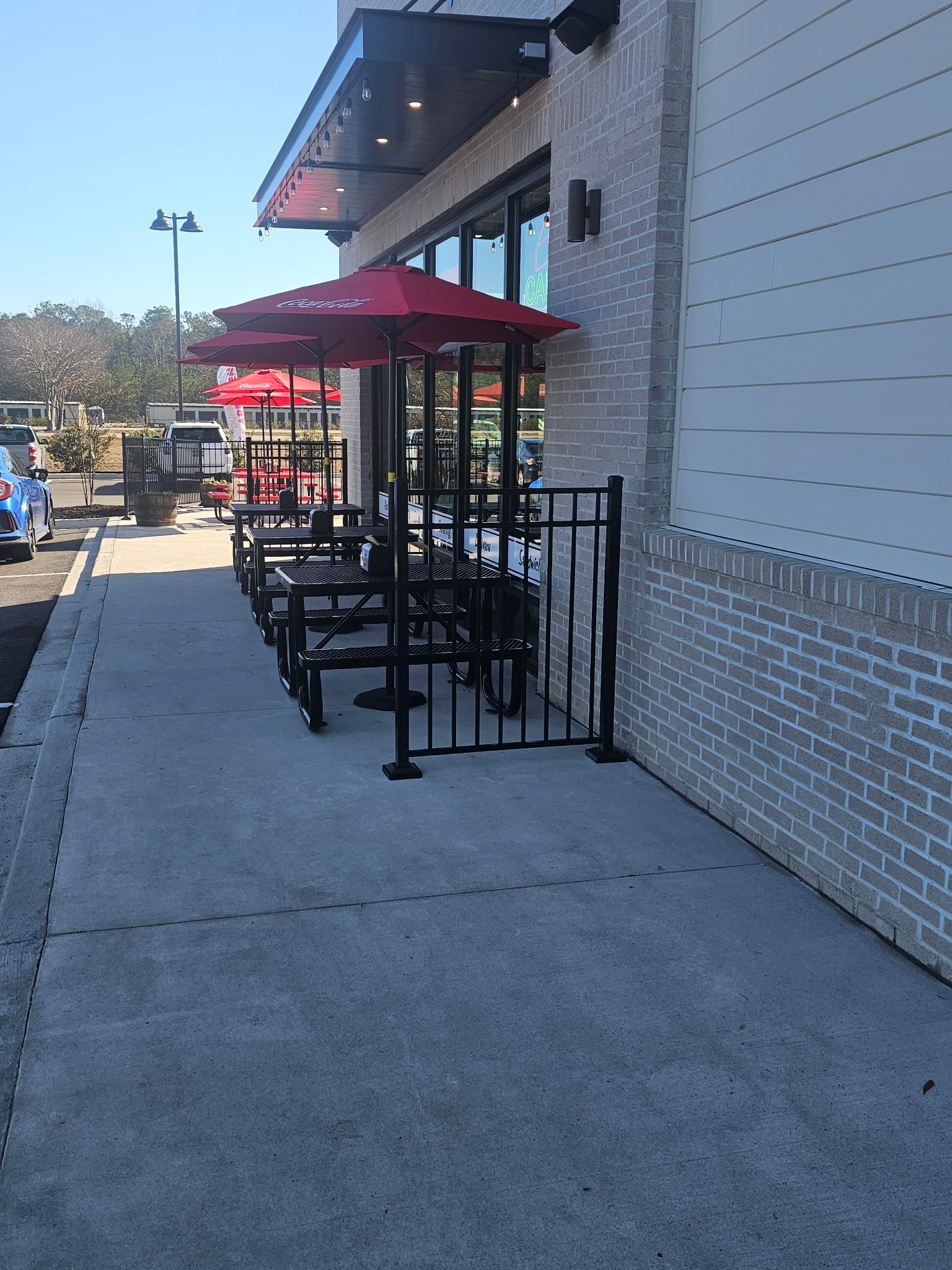 A row of red umbrellas are lined up outside of a restaurant
