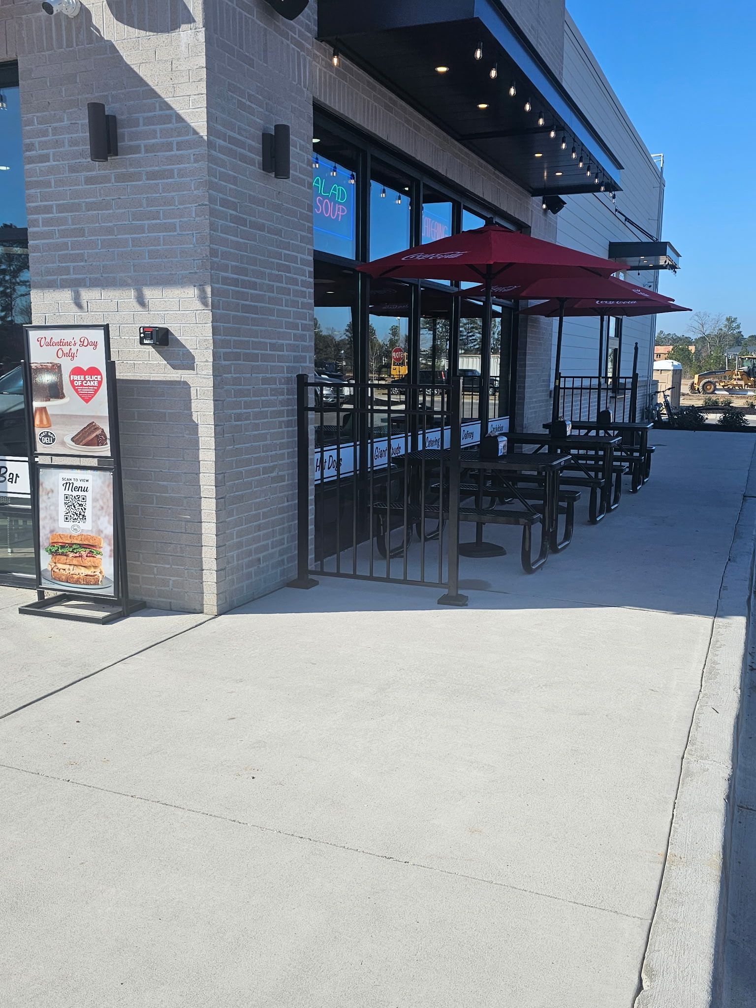 A restaurant with tables and umbrellas outside on a sunny day.