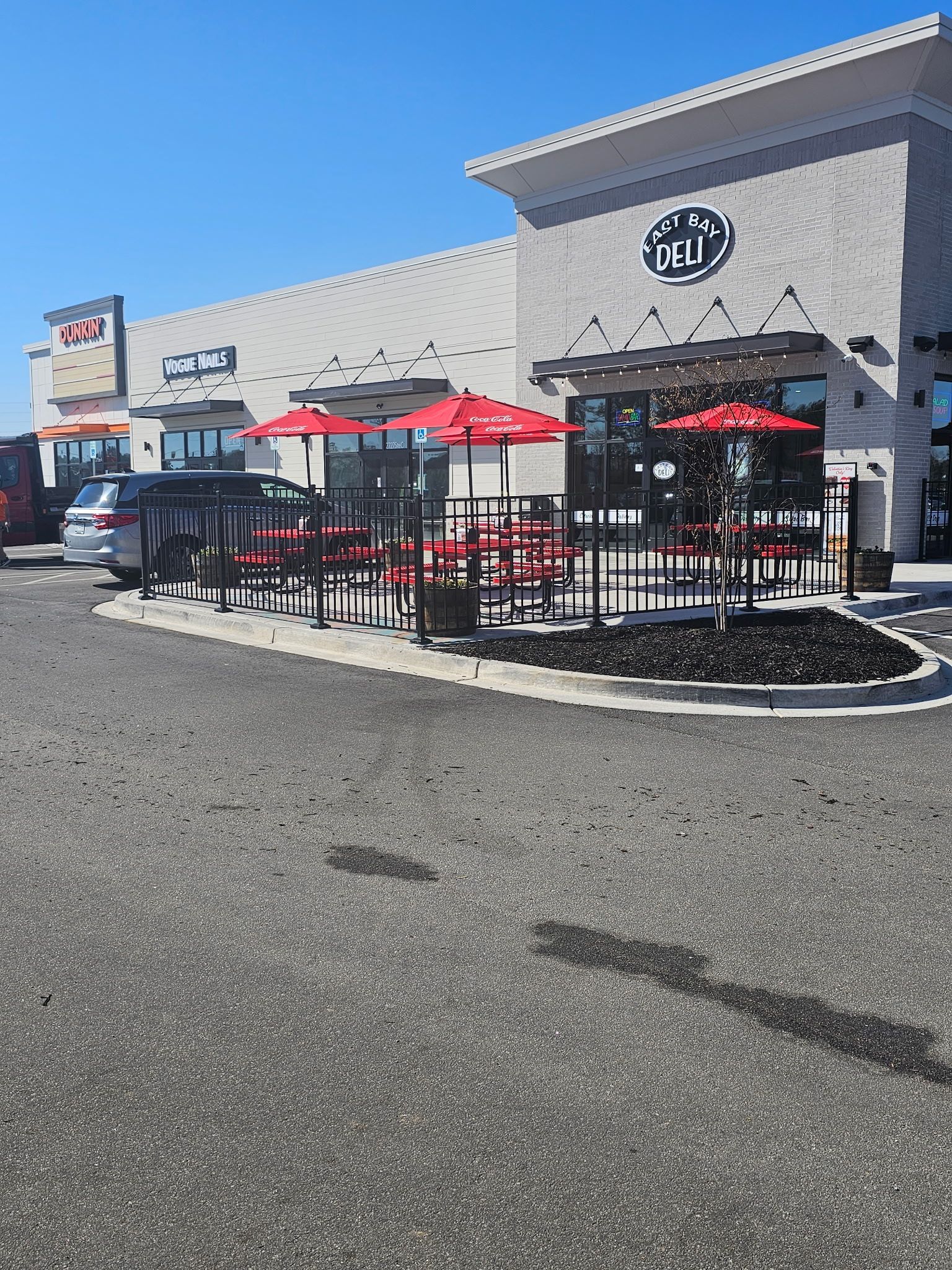A restaurant with tables and umbrellas in front of it.