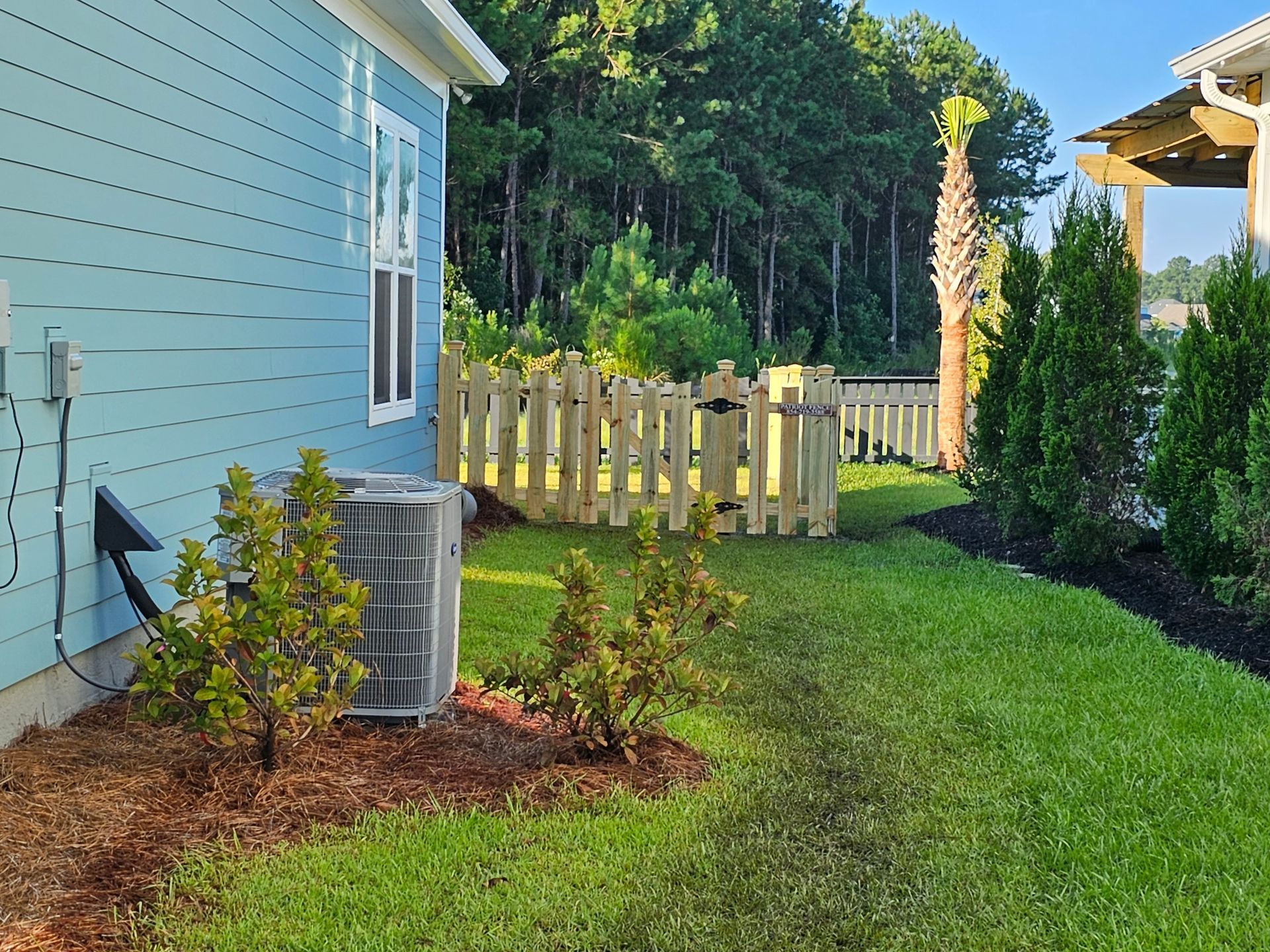 A blue house with a white picket fence in the backyard