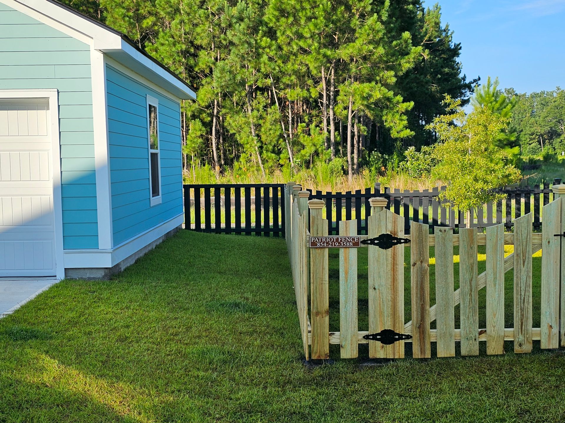 A blue house with a wooden fence in front of it