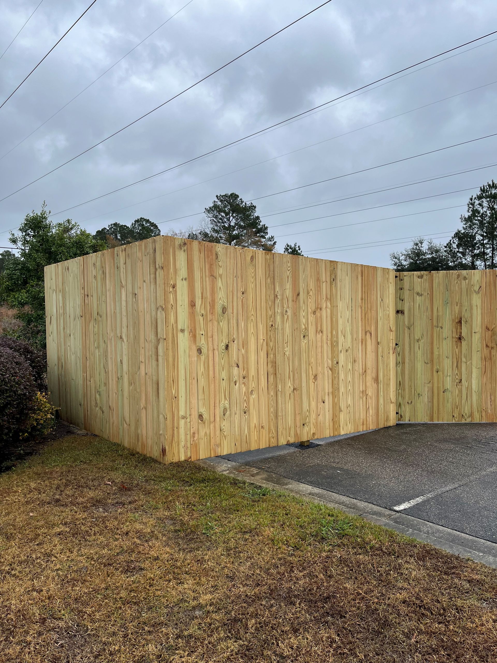 A wooden fence is sitting in the middle of a parking lot.
