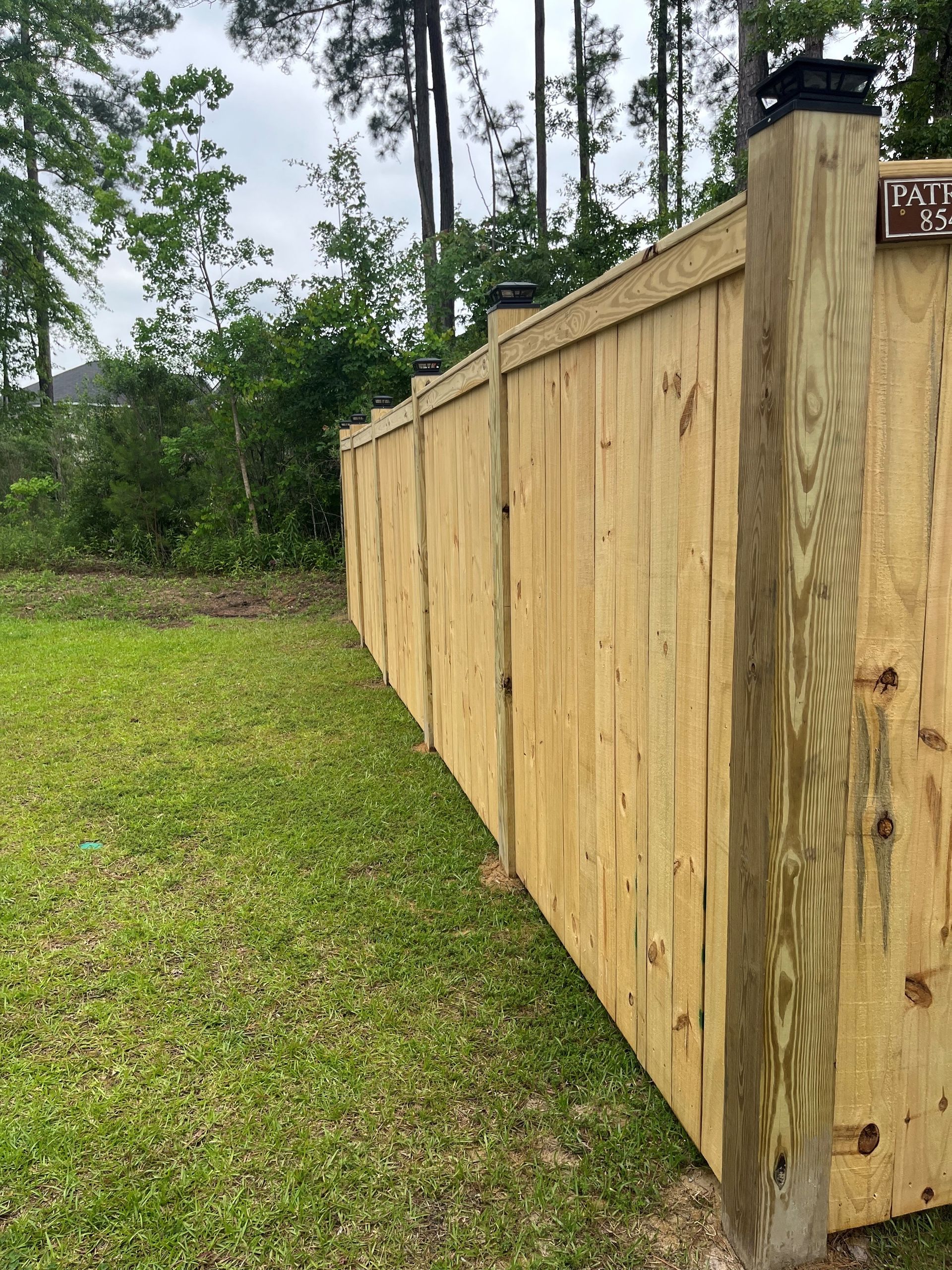 A wooden fence is sitting in the middle of a lush green field.