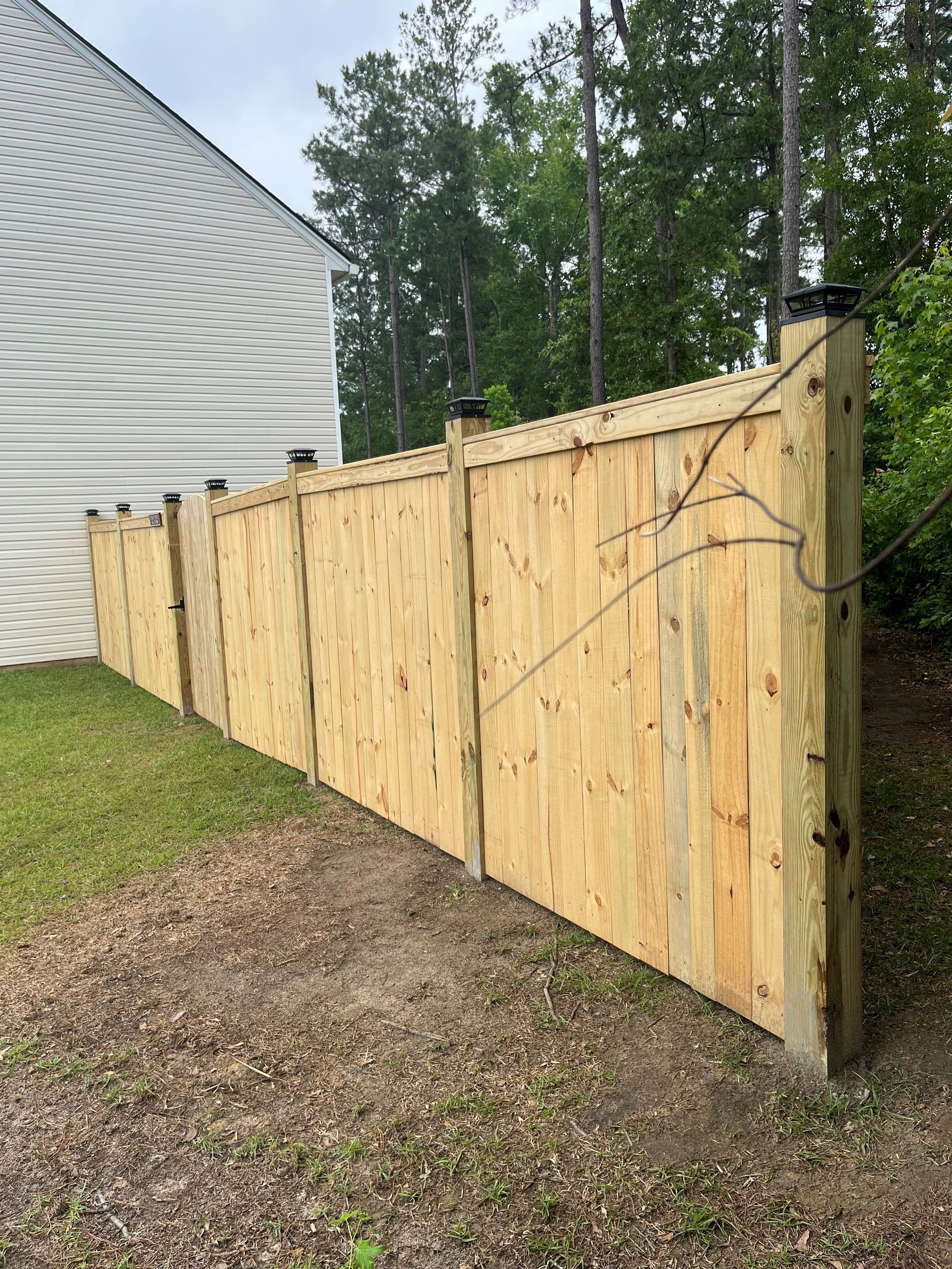 A wooden fence is sitting in front of a house.