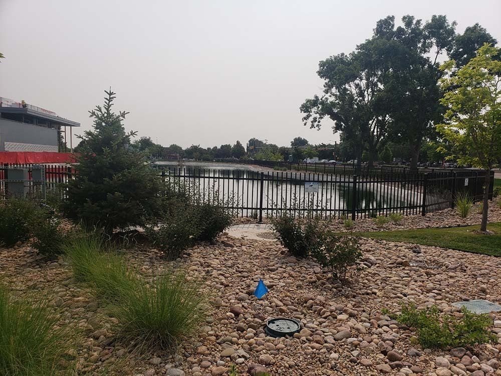 A lake is behind a fence in a park