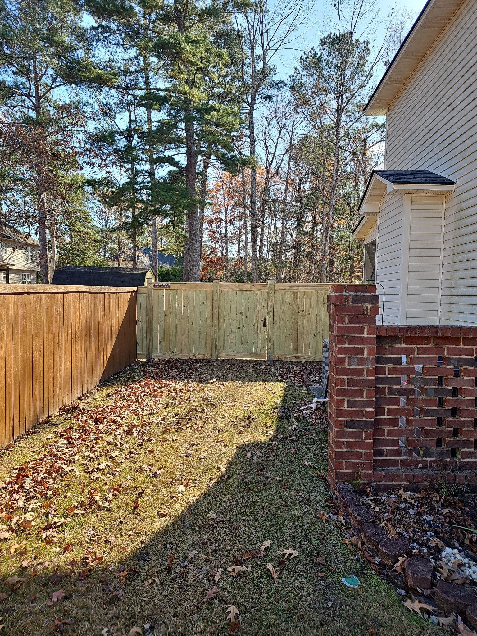 There is a wooden fence in the backyard of a house.