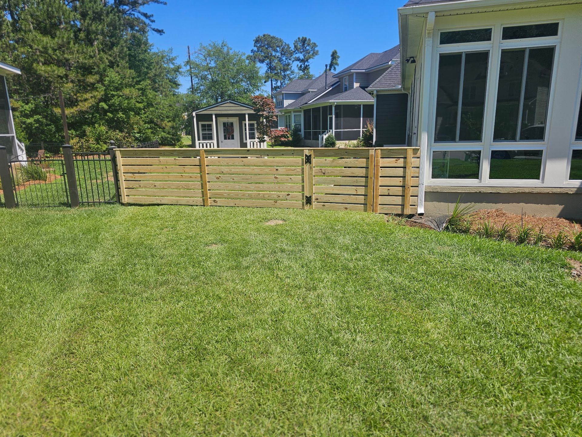There is a wooden fence in the backyard of a house.