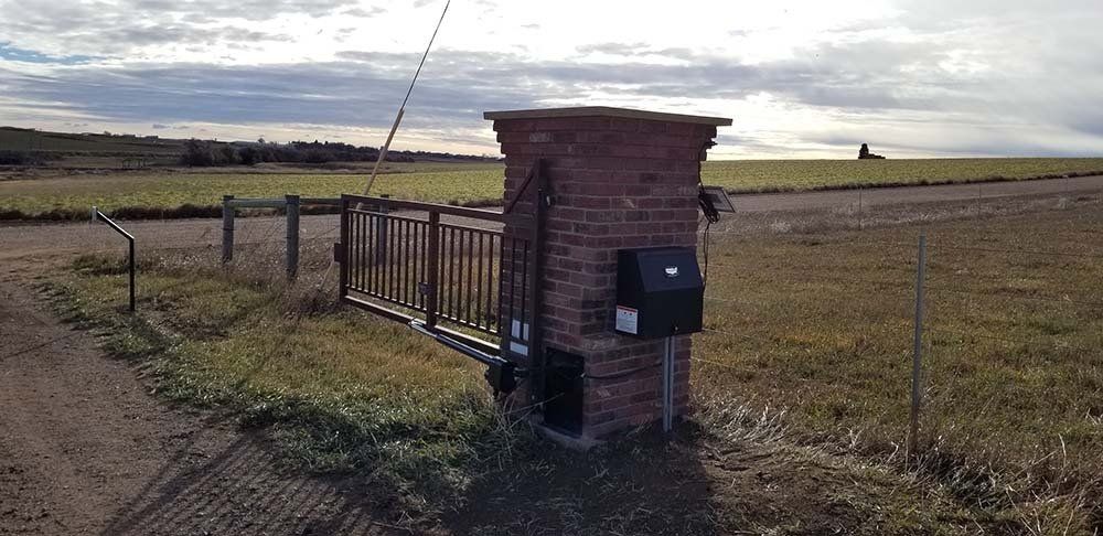 A brick gate with a mailbox attached to it