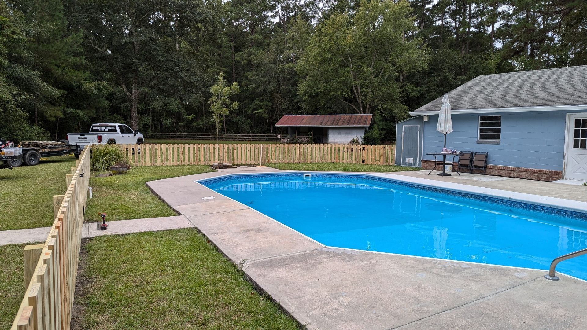 There is a large swimming pool in the backyard of a house.