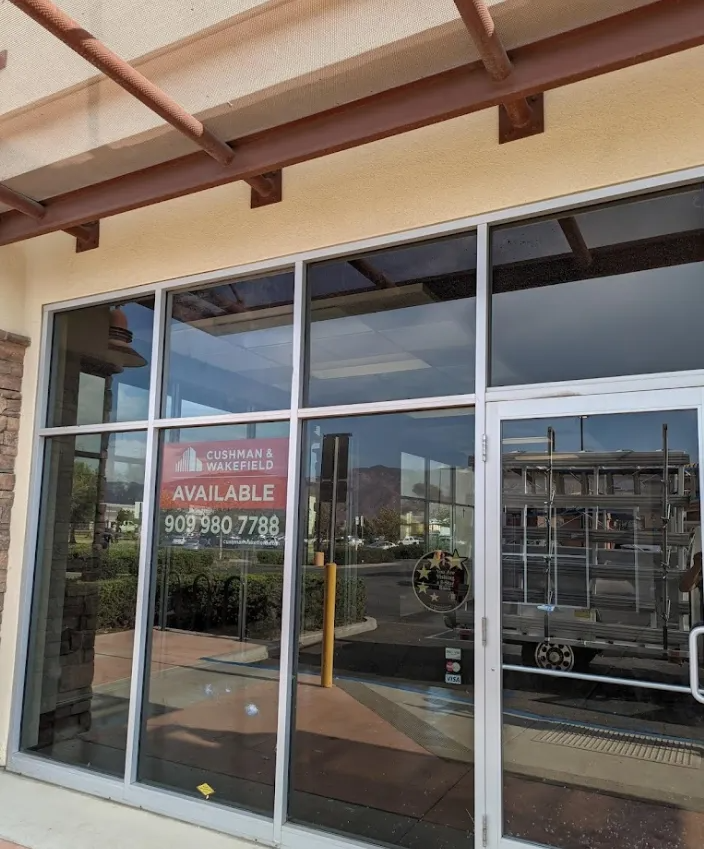 Exterior of an empty commercial space with large windows, 