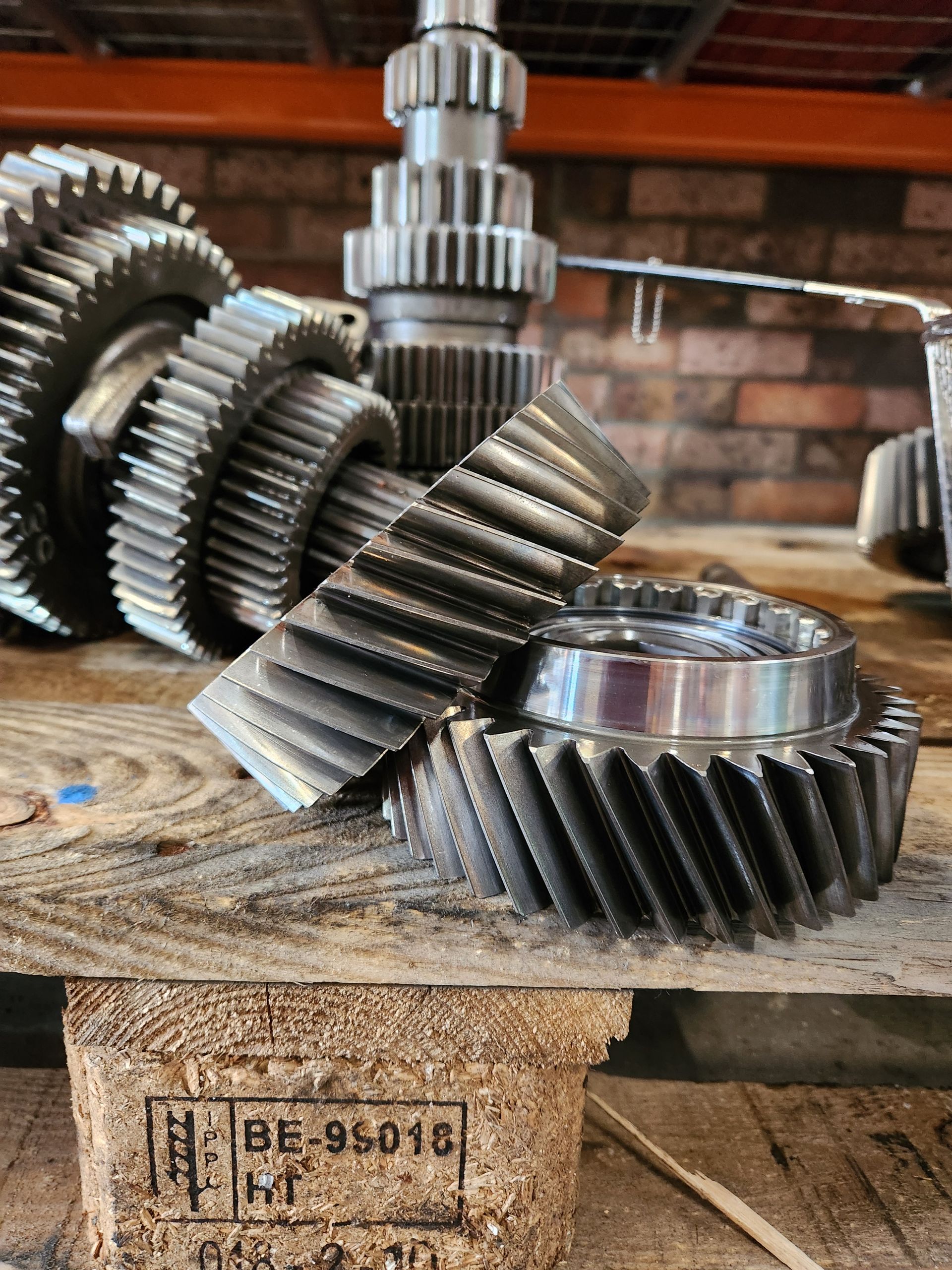 A bunch of gears are sitting on top of a wooden pallet.
